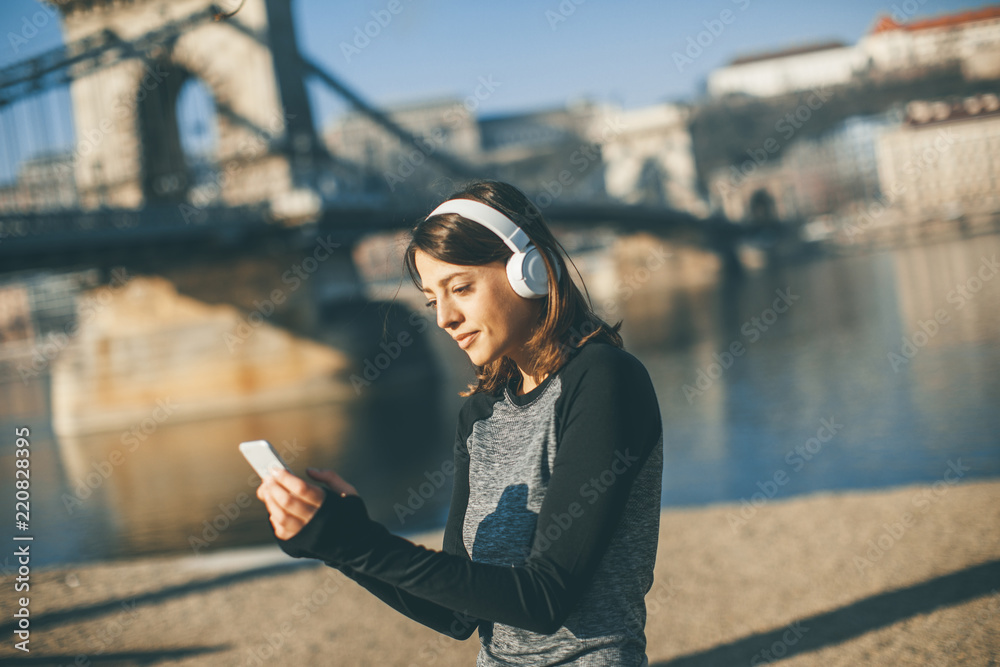 Young athlete woman with mobile phone outdoor