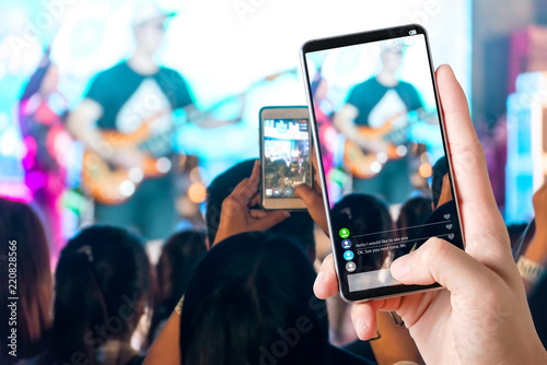 People hands use smart phones record video concert music festival live streaming video on internet to social media comment chat to Friend