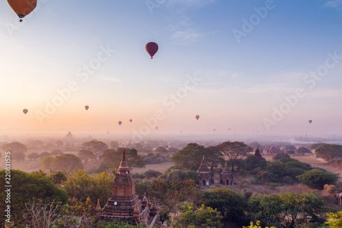  plain of Bagan Myanmar (Burma) whis fog is filled with the Golden light of the sun with the silhouettes of balloons