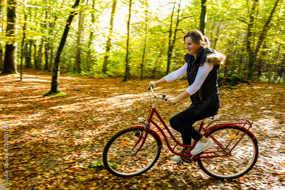 Healthy lifestyle - woman riding bicycle in city park