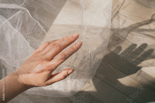 shiny female young hand in glitter shines in the sun with healthy beautiful nails and natural manicure, a gentle pastel picture