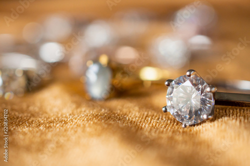 Jewelry diamond rings on golden fabric background close up