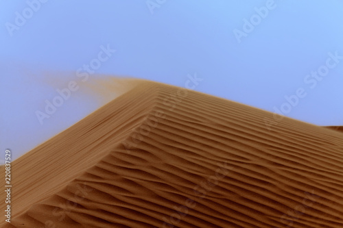 Sand blowing off the top of a sand dune, Riyadh, Saudi Arabia photo