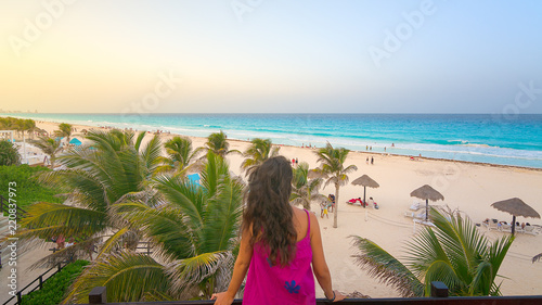 Young woman watching the beautiful Cancun beach at sunset, Mexico