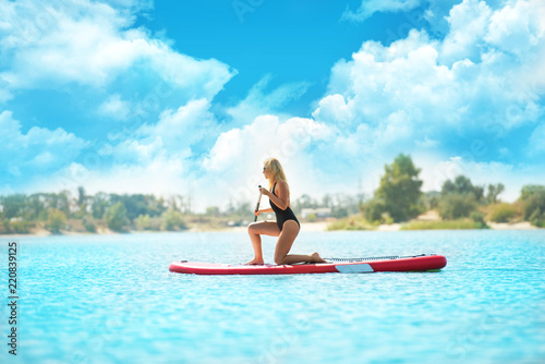 Young sexy woman swimming on stand up paddle board.Water sports , active lifestyle.