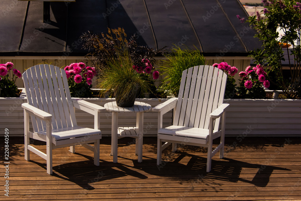 white wooden garden furniture, table and two armchairs. city cafe terrace. Stockholm, Sweden
