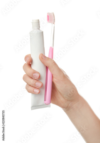 Woman holding toothbrush and paste against white background. Dental care