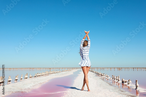 Beautiful woman posing near pink lake on summer day © New Africa