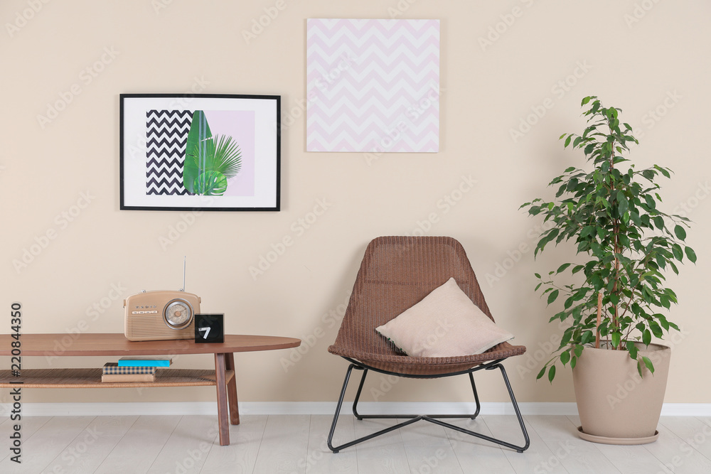 Obraz premium Stylish living room interior with armchair and houseplant near beige wall