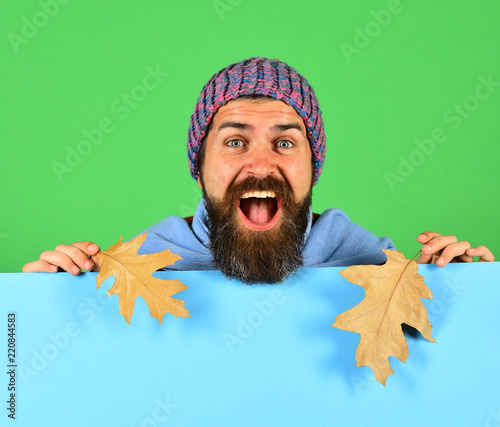 Hipster with beard and excited face wears warm clothes
