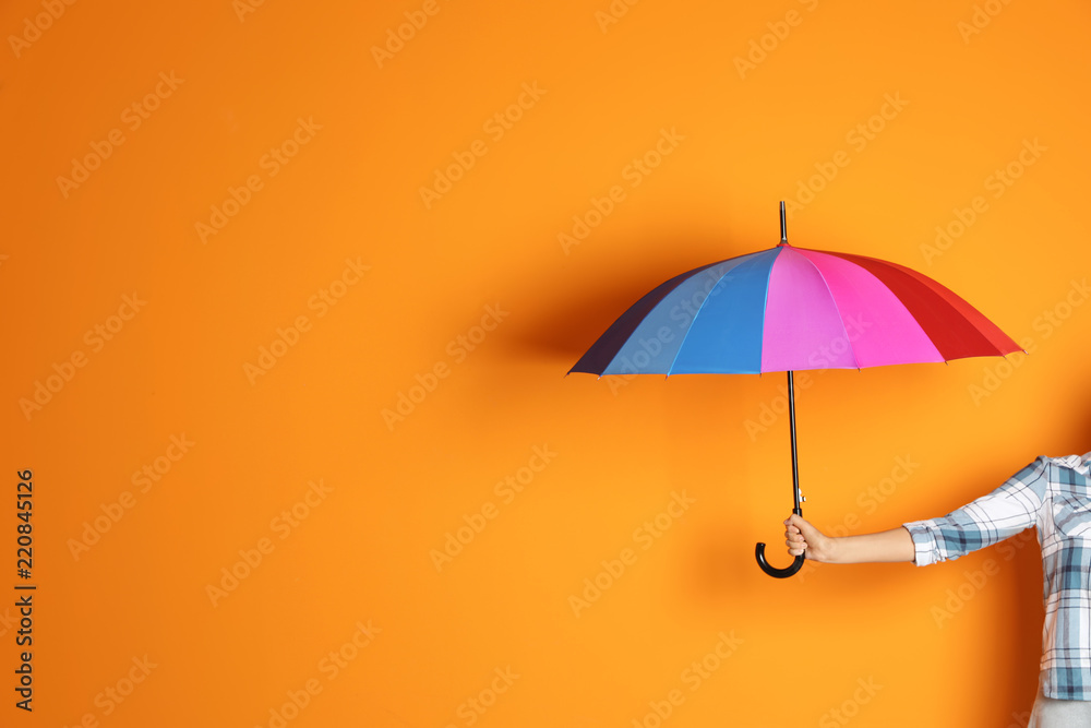 Obraz premium Woman holding beautiful umbrella on color background with space for design