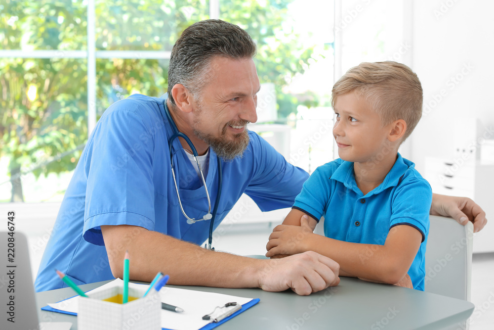 Male medical assistant consulting child in clinic Male medical assistant consulting child in clinic