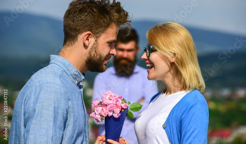 Lovers meeting outdoor flirt romance relations. Unrequited love concept. Couple in love dating while jealous husband fixedly watching on background. Couple romantic date lover present bouquet flowers