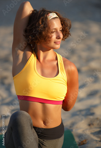 Beautiful young woman doung fitness exercises outdoor photo