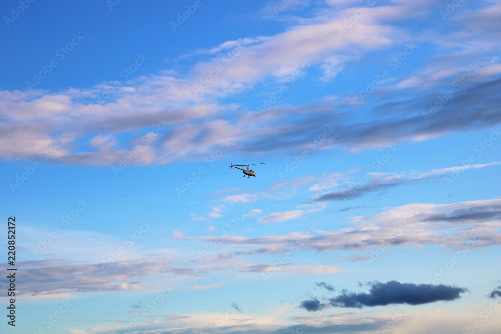 Helicopter flying after the passing sun Helicopter flying after the passing sun