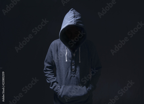 Canvastavla Mysterious man with hoodie in silhouette on black background