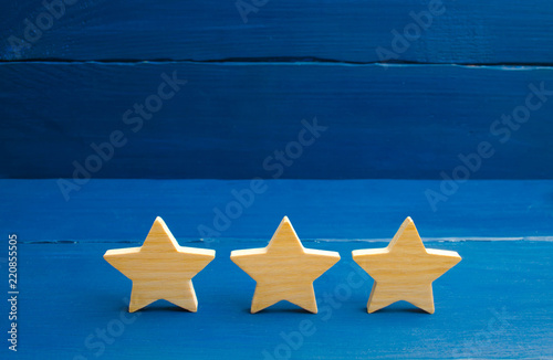 The rating of the hotel, restaurant, mobile application. Three stars on a blue background. The concept of rating and evaluation. Quality service, buyer choice. Success in business