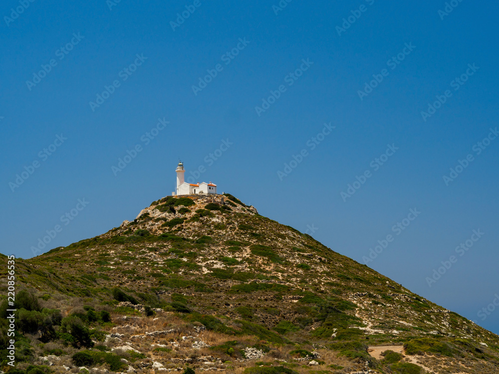 Lighthouse is located on a high point of the island near the ruins of the ancient city of Knidos, cloudless sky in sunny day at the confluence of two seas - Mediterranean sea and Aegean sea, Turkey
