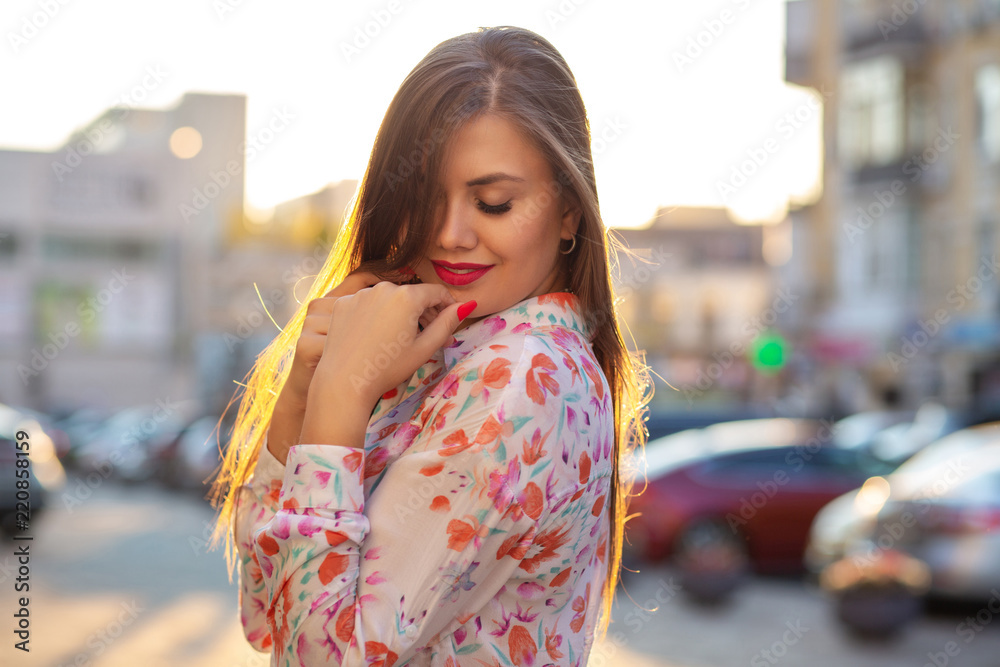 Delightful brunette girl wearing blouse, posing at the evening city background Delightful brunette girl wearing blouse, posing at the evening city background