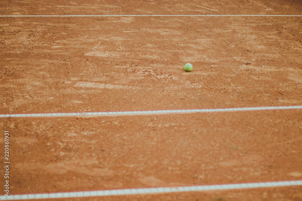 Tennis ball on grunge orange court