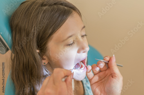 Little girl at the reception in the dentist's office. little girl sitting in a chair near a dentist after dental treatment. Little girl sitts in the dentist's office