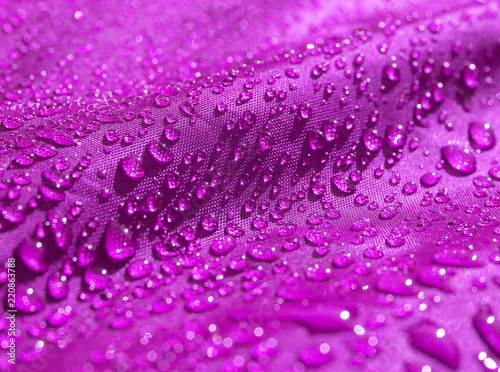 Purple waterproof fabric with waterdrops close up