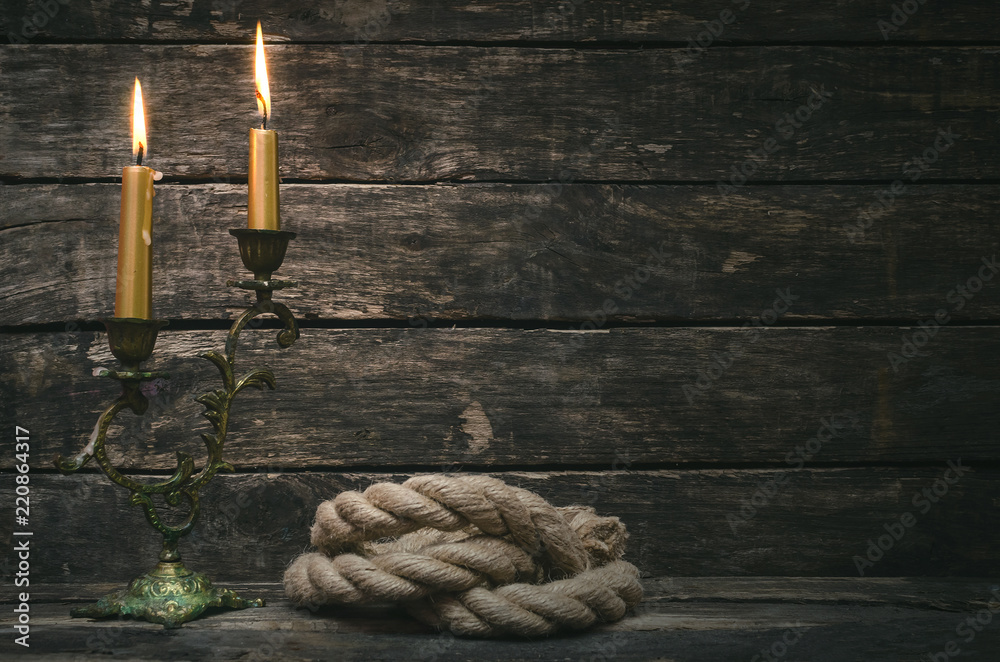 Mooring rope and burning canlde on aged wooden table of pirate ...