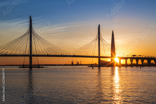 Cable-stayed bridge of Western high-speed diameter through Peter's fairway and the tower of Lakhta center, at sunset, Saint-Petersburg, Russia