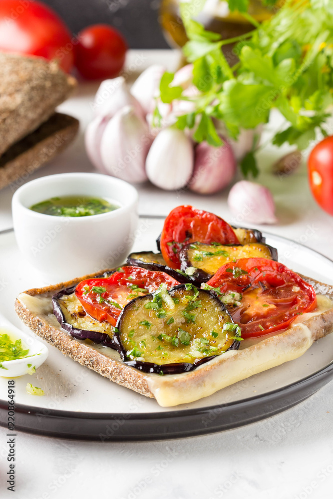 Open sandwich with eggplant, tomato, cheese and olive oil with greens and garlic. Delicious snack, homemade lunch, tasty food Open sandwich with eggplant, tomato, cheese and olive oil with greens and garlic. Delicious snack, homemade lunch, tasty food