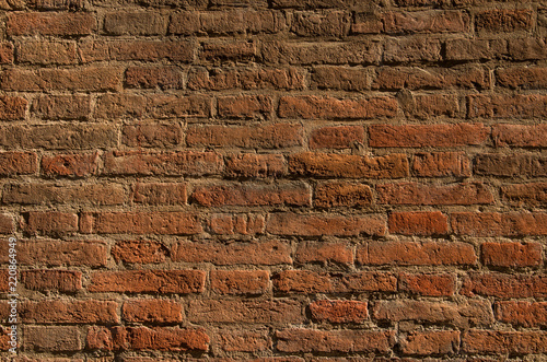 Texture of an old brick wall in contrast lighting. Natural background.