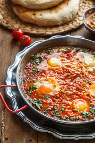 Big shakshuka in iron pan, close view.