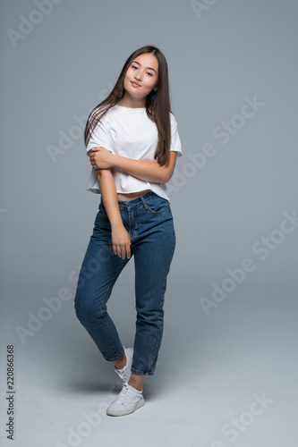 Full body portrait of happy smiling beautiful asian young woman, isolated over gray background