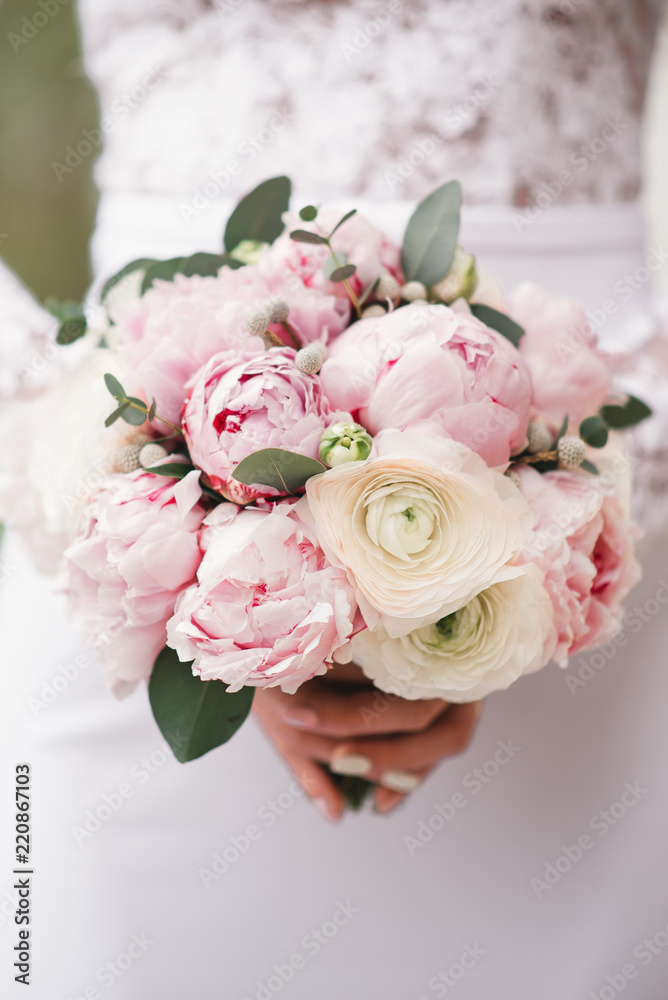 Beautiful wedding bouquet for the bride with pink peonies and white peony roses