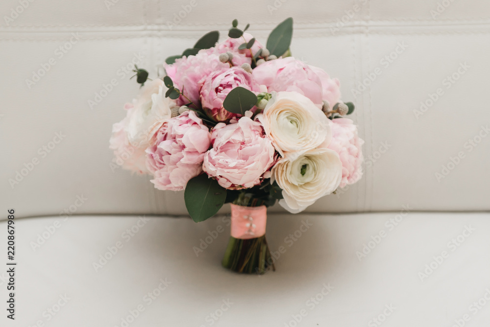 Beautiful wedding bouquet for the bride with pink peonies and white peony roses