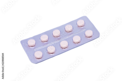 Pink pills in a package isolated on a white background