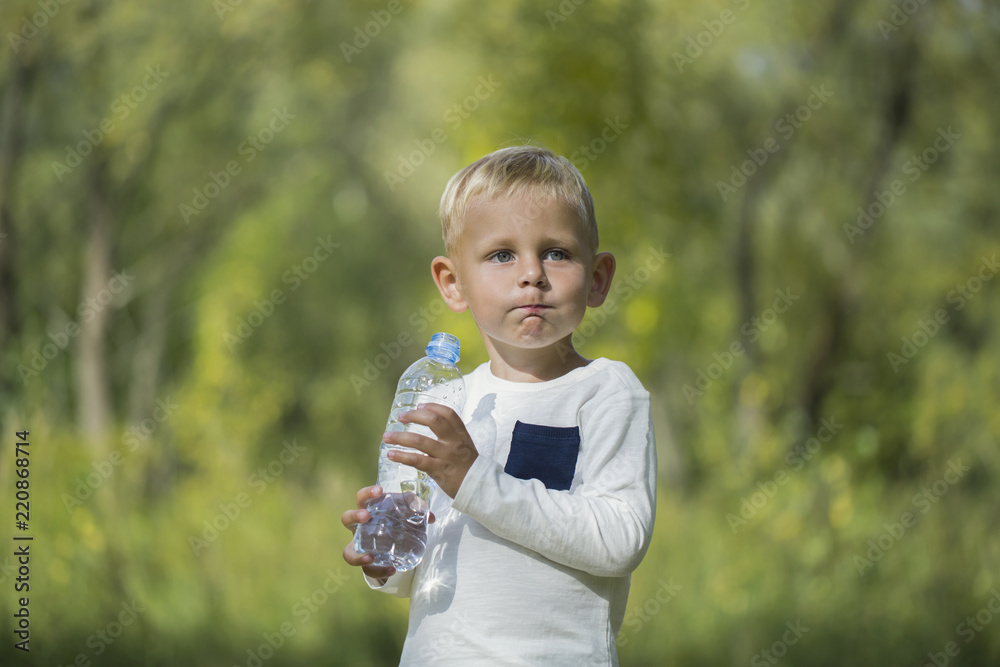 A small boy with a bottle of still water A small boy with a bottle of still water