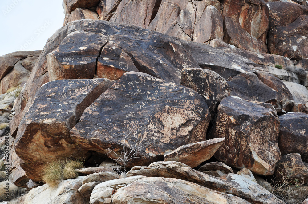 A pile of rocks with petroglyphs carved into them A pile of rocks with petroglyphs carved into them