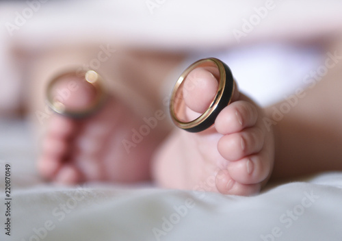 Baby wearing wedding rings on big toes
