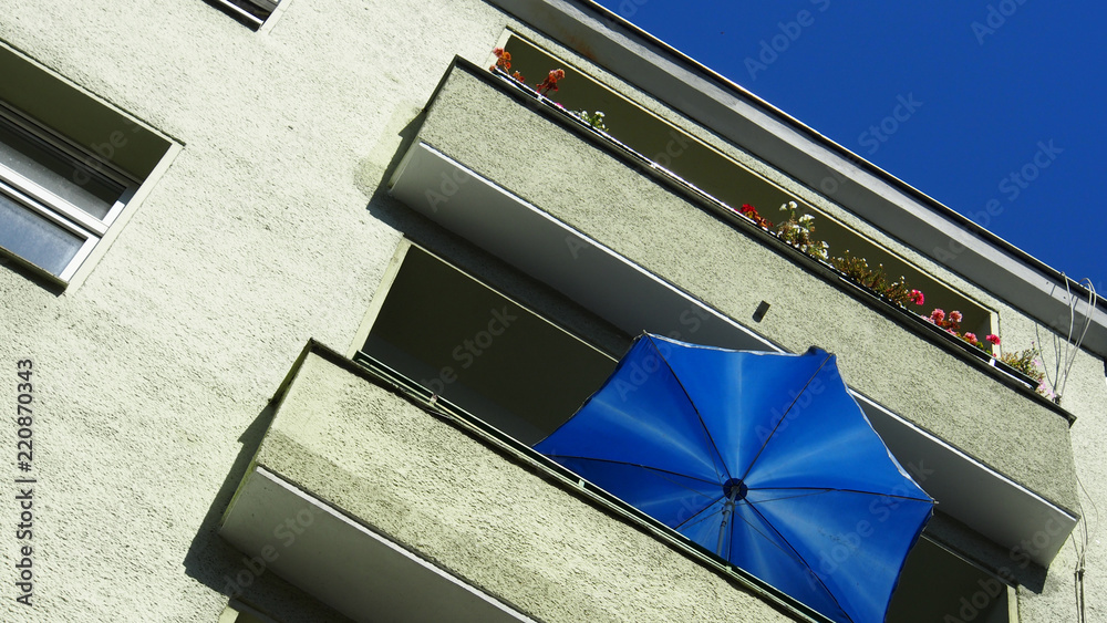 Fototapeta premium Deutschland: Sommer auf dem Balkon, blauer Sonnenschirm, blauer Himmel