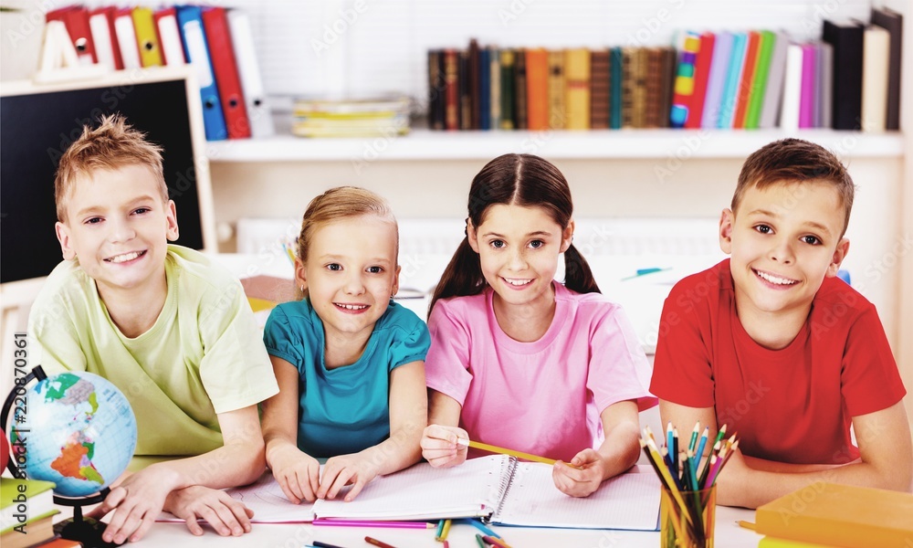 Fototapeta premium Friendly school children with books at class