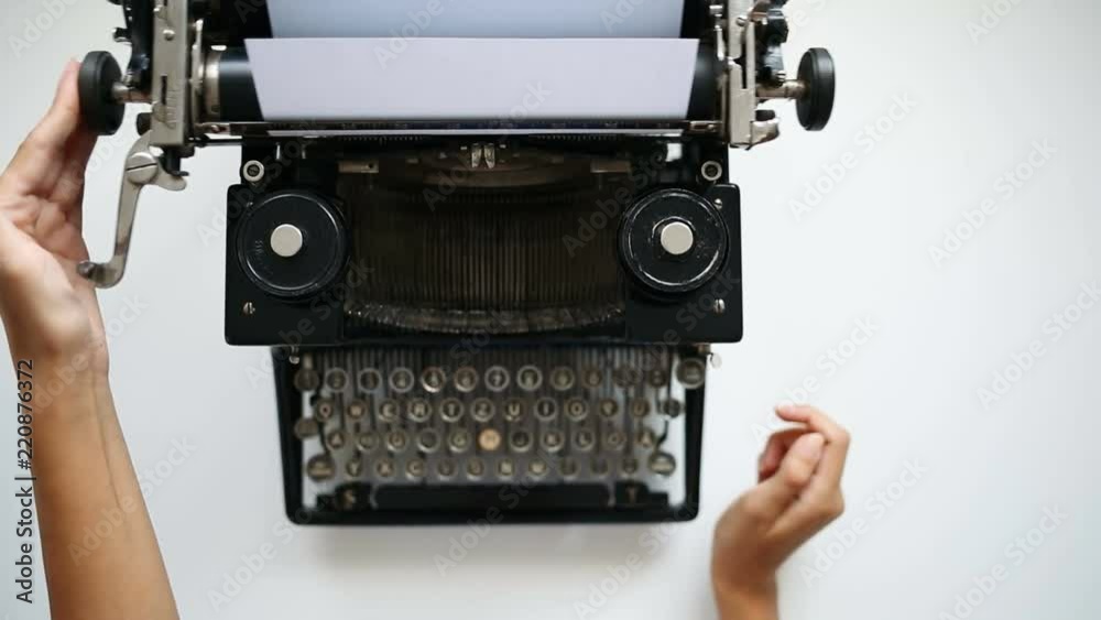 High angle view of woman hands insert paper into typewriter