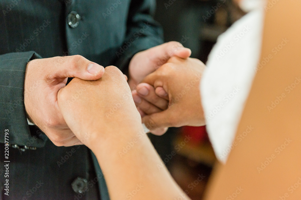 Fototapeta premium Young married couple holding hands, ceremony wedding day.