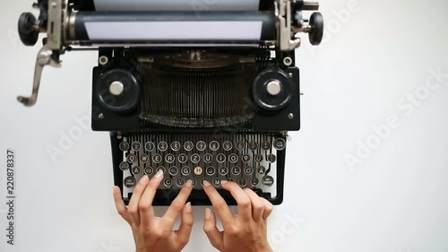 High angle view of writer typing on vintage typing machine. Writer typing with retro typewriter photo