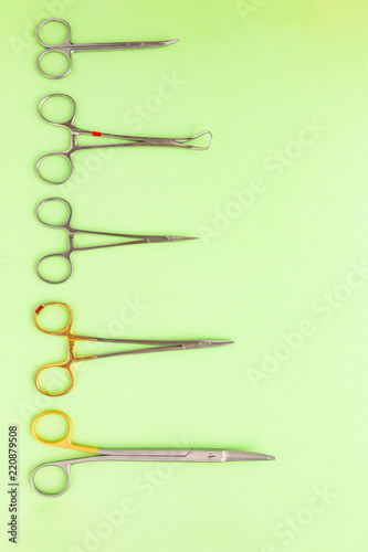 Medical equipments including surgical instruments on a green background. top view, copy spase