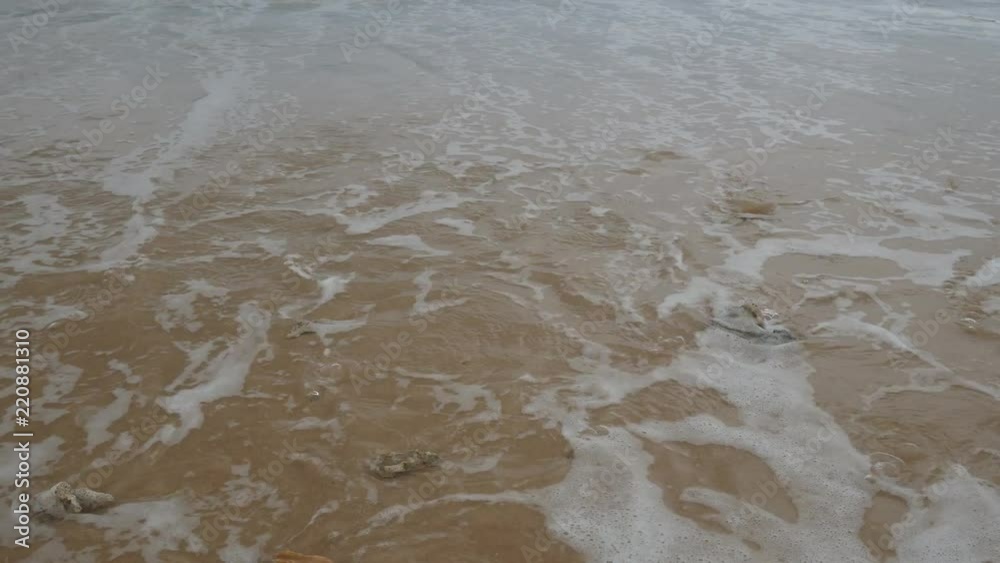 Beautiful sand beach with dead coral  and soft wave in sea water , cloudy rainy sky day