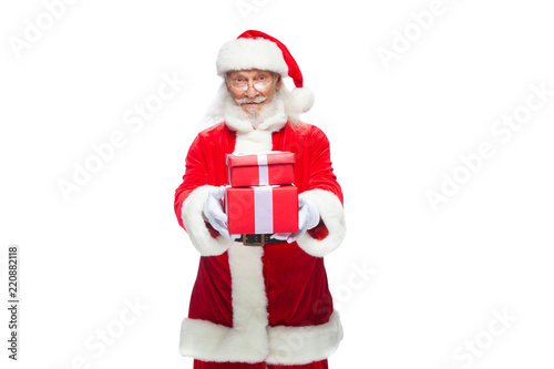 Christmas. Smiling Santa Claus in white gloves is holding two gift red boxes with a bow, one on the other. Isolated on white background.