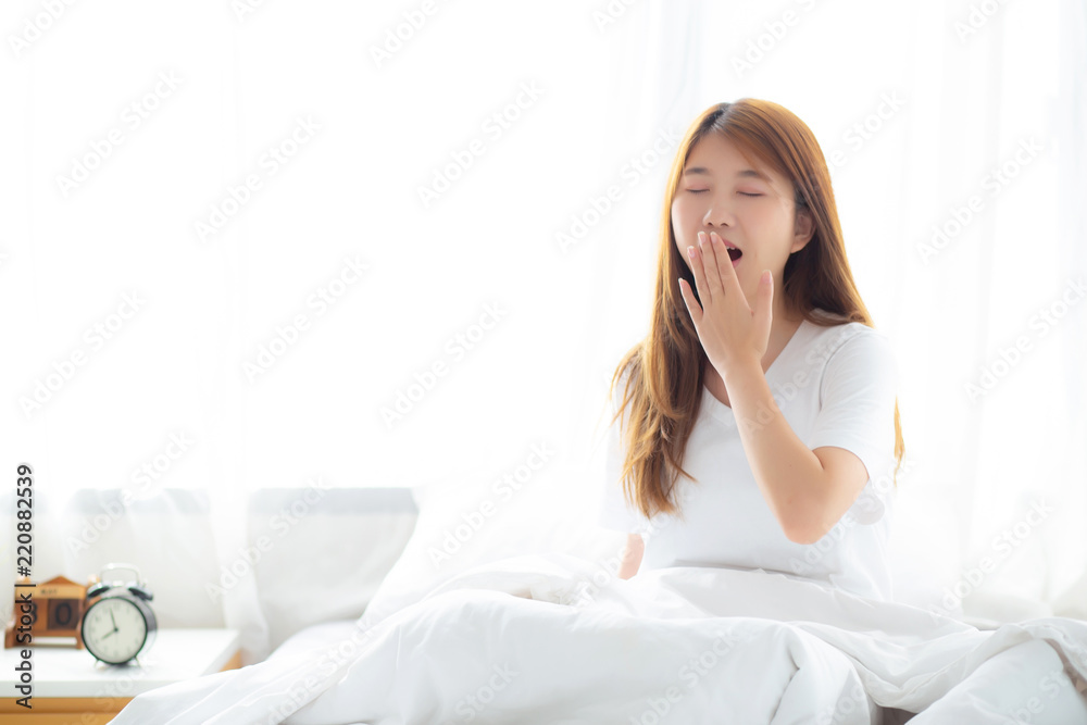 Beautiful of portrait young asian woman yawn sitting with sleep on bed at bedroom, girl wake up after resting and leisure with wellness, lifestyle concept. Beautiful of portrait young asian woman yawn sitting with sleep on bed at bedroom, girl wake up after resting and leisure with wellness, lifestyle concept.