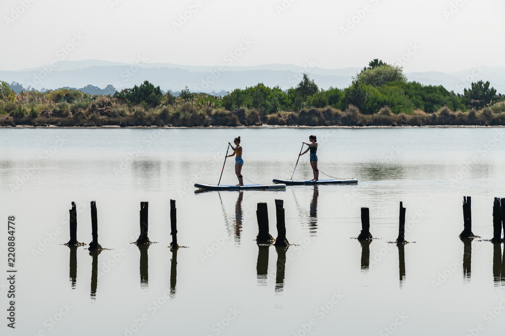 Two women stand up paddleboarding Two women stand up paddleboarding