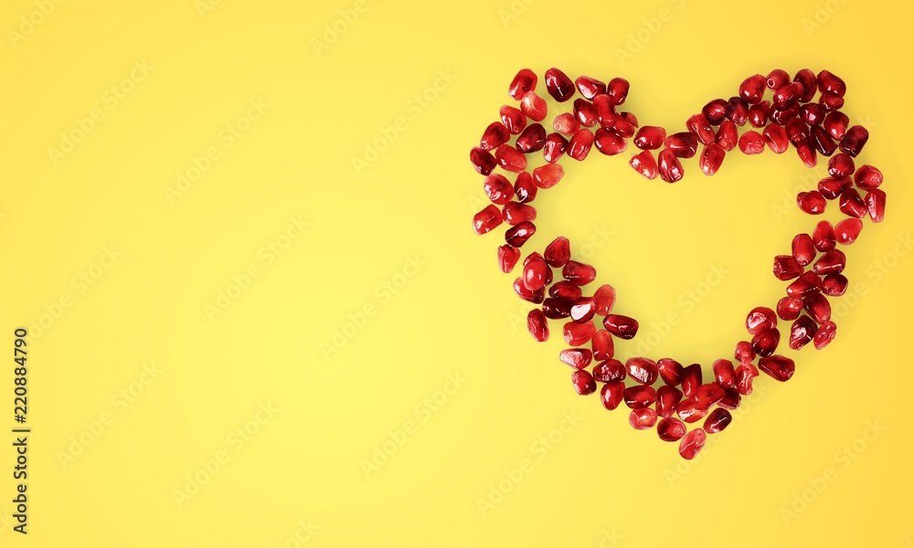 Pomegranate seeds in shape of heart on white background