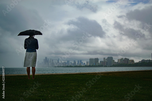 Woman Holding Umbrella in Wind and Rain Looking at the Windy City Chicago USA